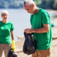 senior volunteers doing their best gathering garbage on river bank