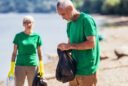 senior volunteers doing their best gathering garbage on river bank
