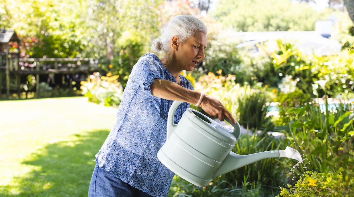 senior woman watering spring flowers