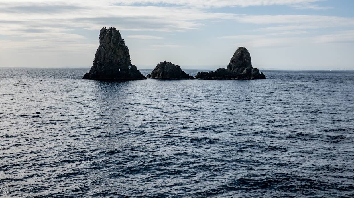 The cliffs of Cyclops (Faraglioni dei Ciclopi) in the sea near Aci Trezza town, Sicily, Italy. Large stones are believed to be thrown at Odysseus